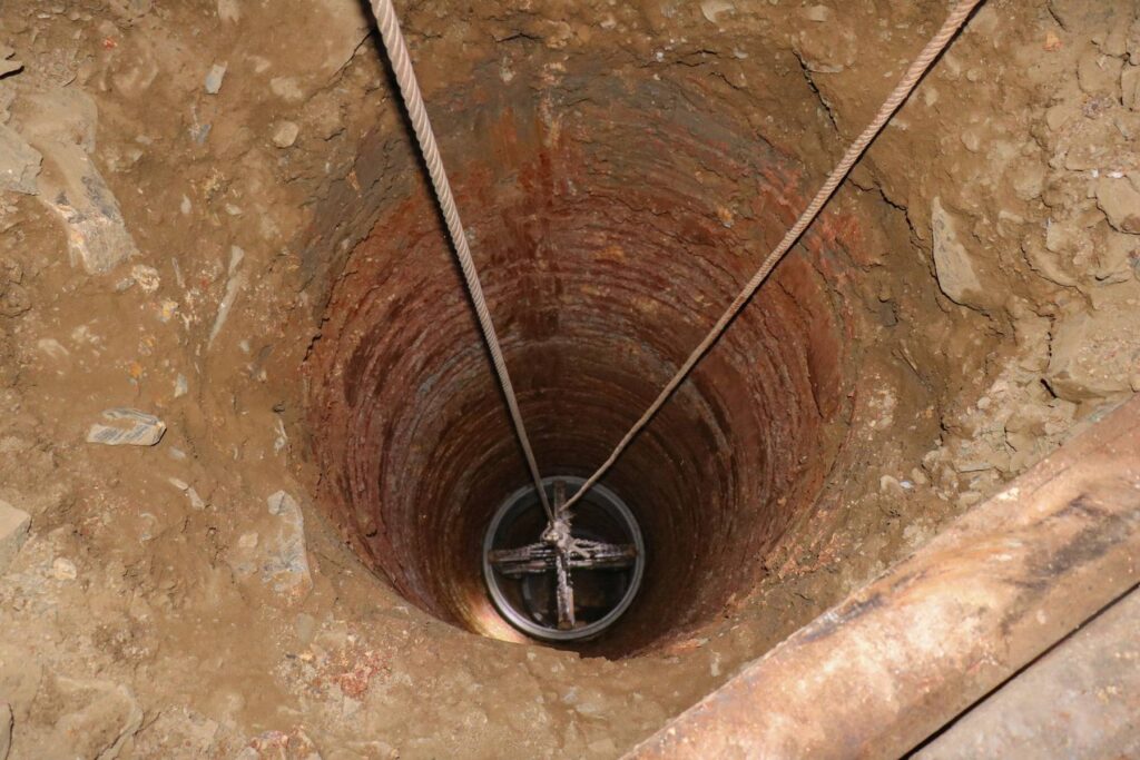 Steel well casing lowered on cables into a well shaft